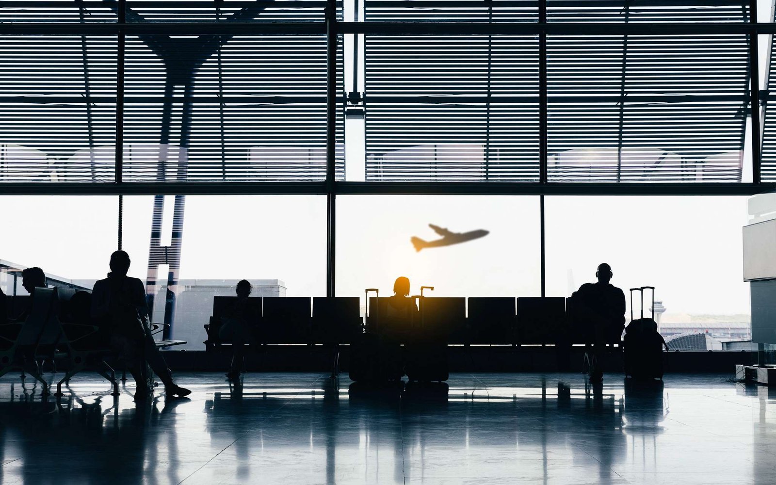 As companhias aéreas mais inseguras do mundo. Silhuetas de pessoas à espera nas portas de embarque de um avião.