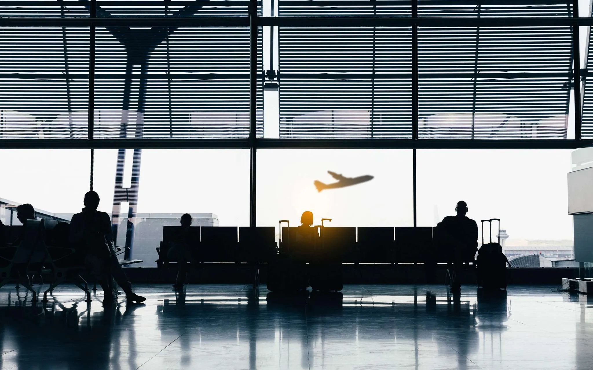 The most insecure airlines in the world. Silhouettes of business people traveling on airport; waiting at the plane boarding gates.