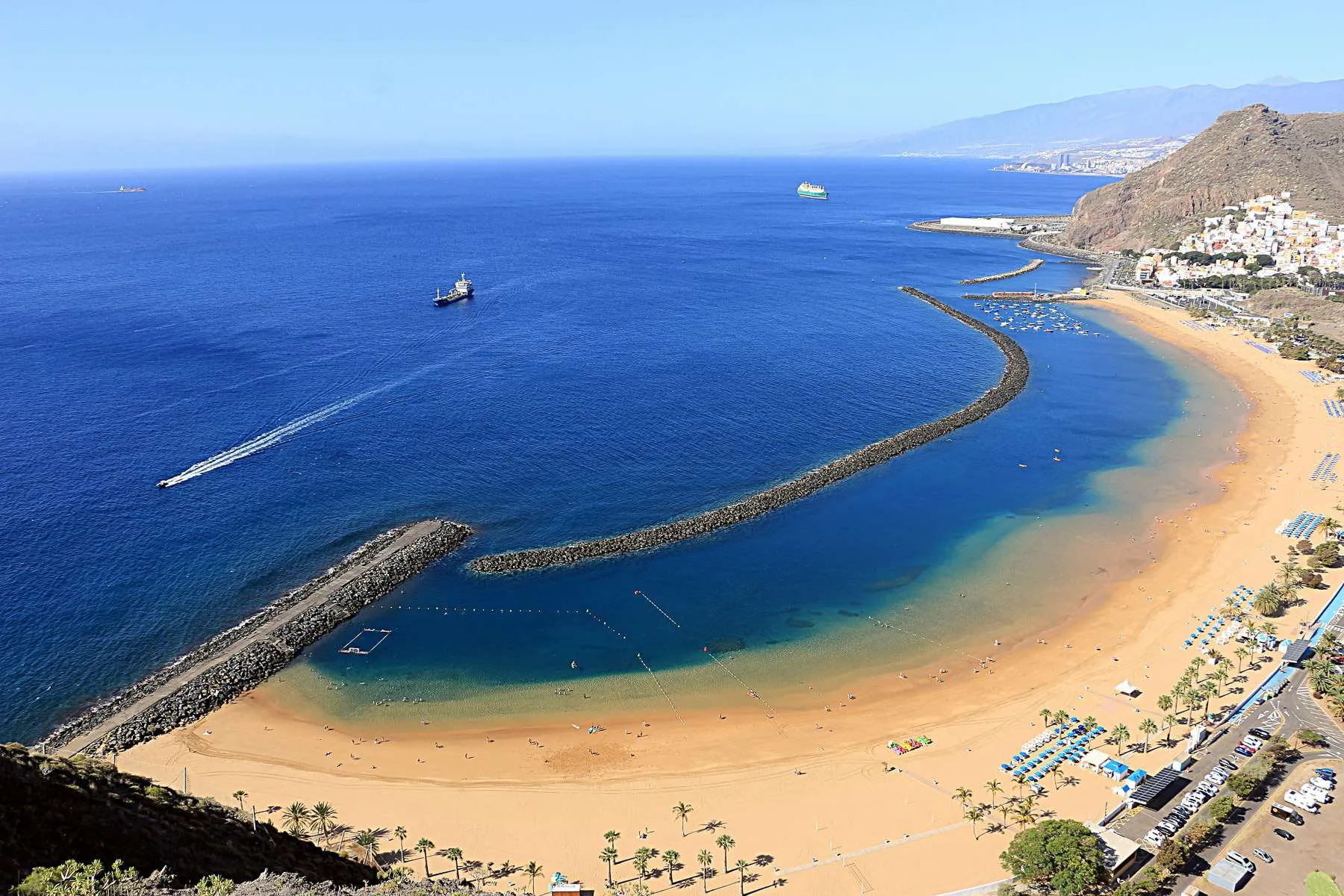 The golden sands of Playa de las Teresitas in Tenerife, a calm and budget-friendly beach in Europe, are perfect for family getaways.