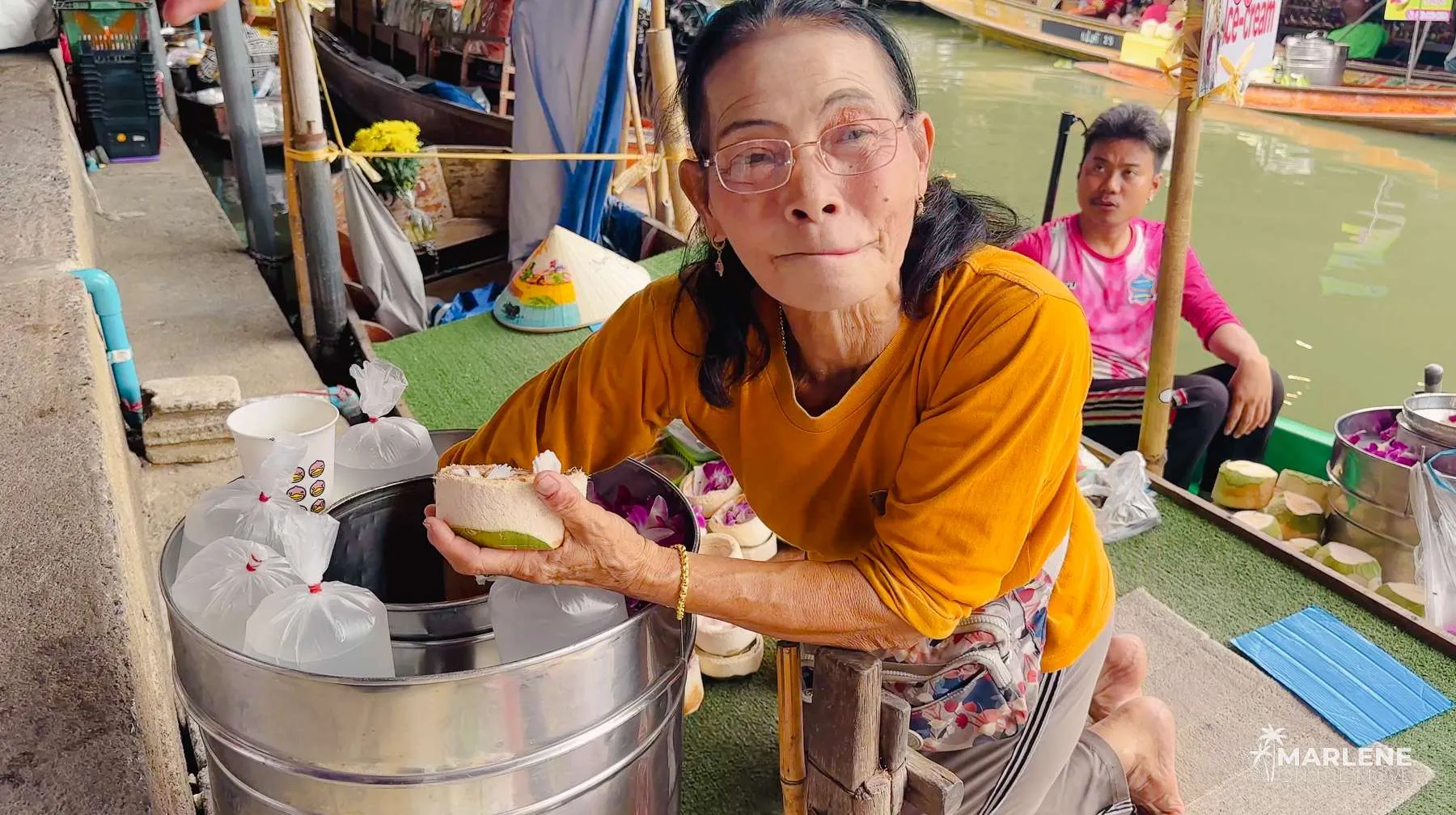 Thai vendor preparing a coconut ice cream on a boat at the Floating Market