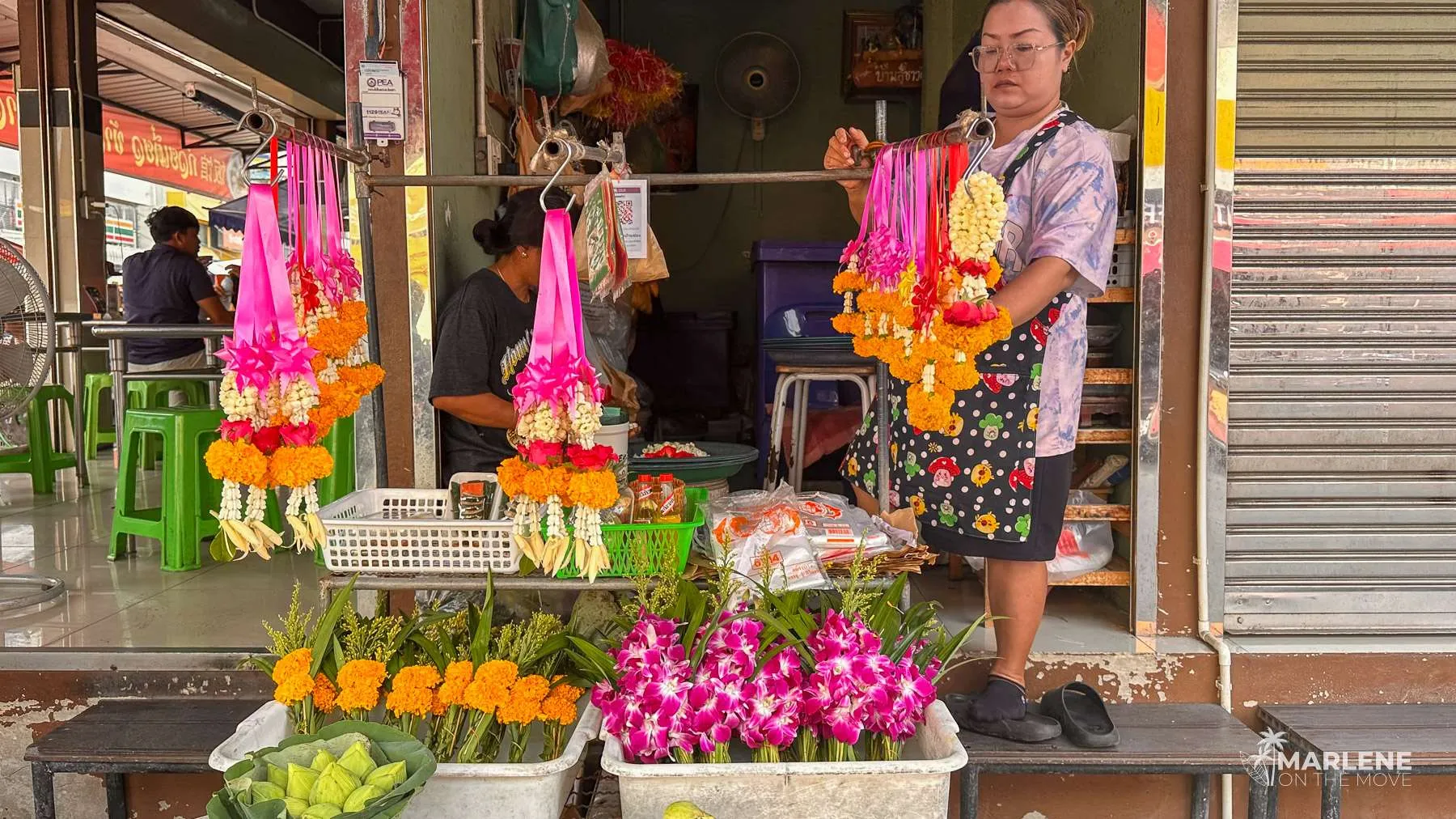 Women on a flower stall at Maeklong Railway Market