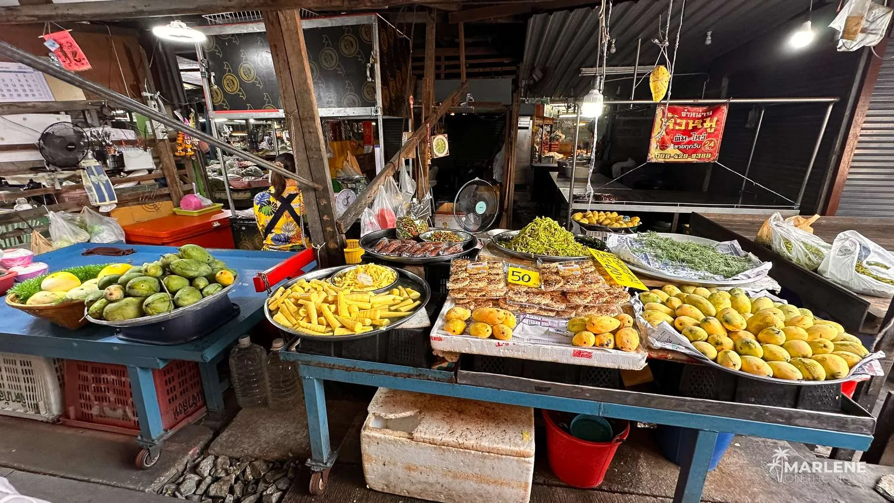Local food stalls lined along the train tracks at Maeklong Market