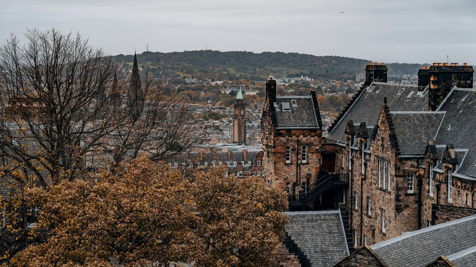 Paredes de pedra e telhados enevoados da Cidade Velha de Edimburgo numa manhã nublada.