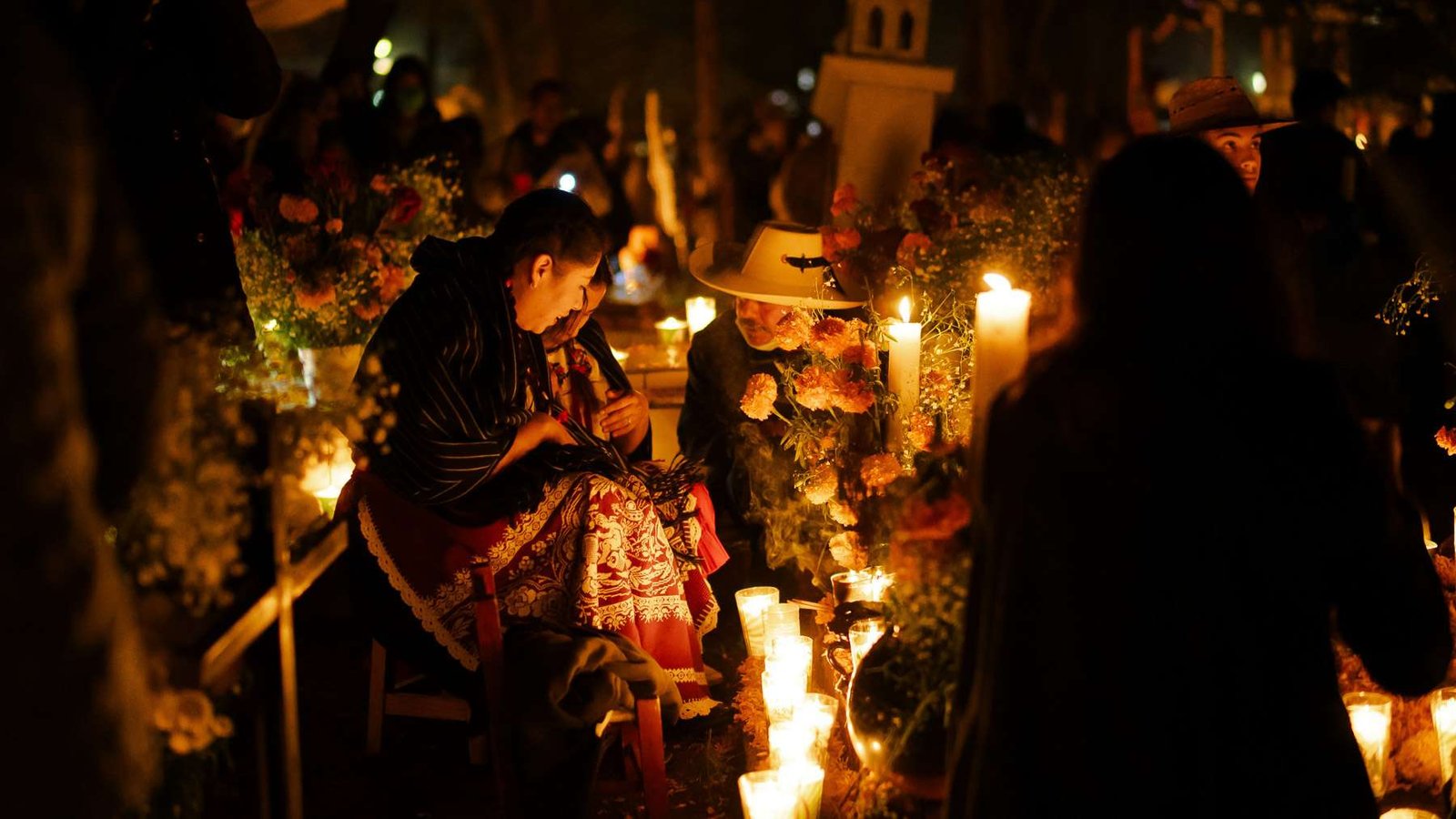 Celebrações do Día de los Muertos num cemitério à noite