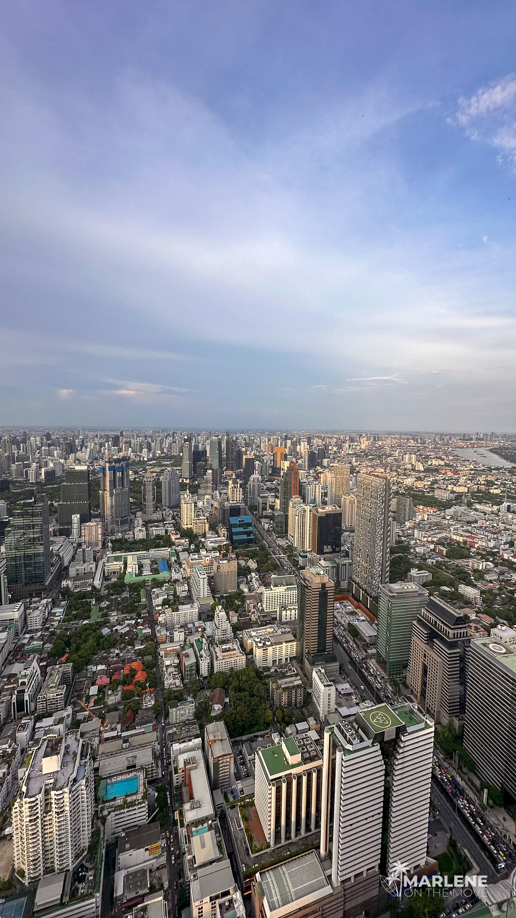 Vista aérea da paisagem urbana de Banguecoque, com edifícios densos que se estendem até ao horizonte.
