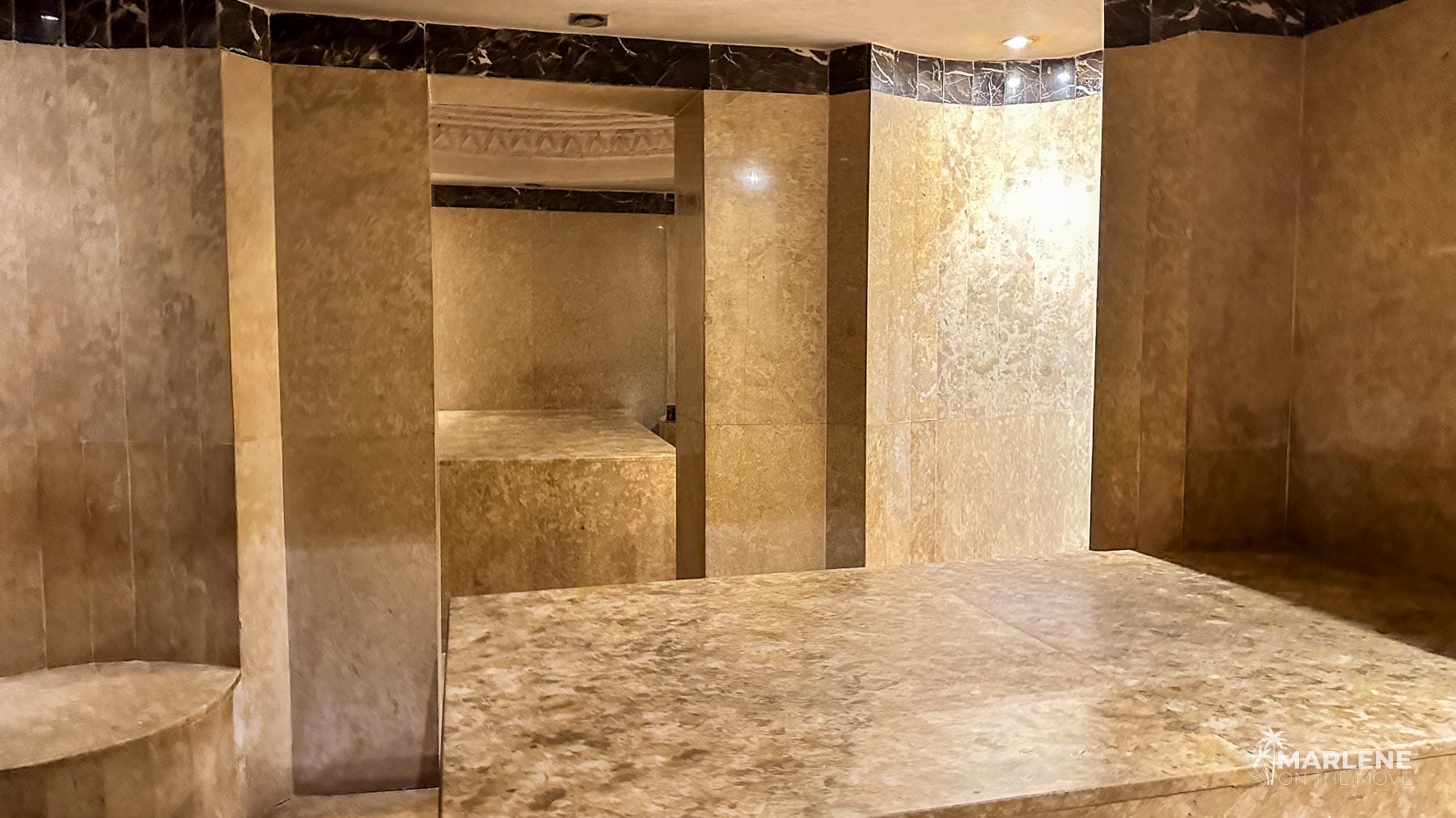 Traditional hammam interior in Marrakech, Morocco, with heated marble slab and tiled walls