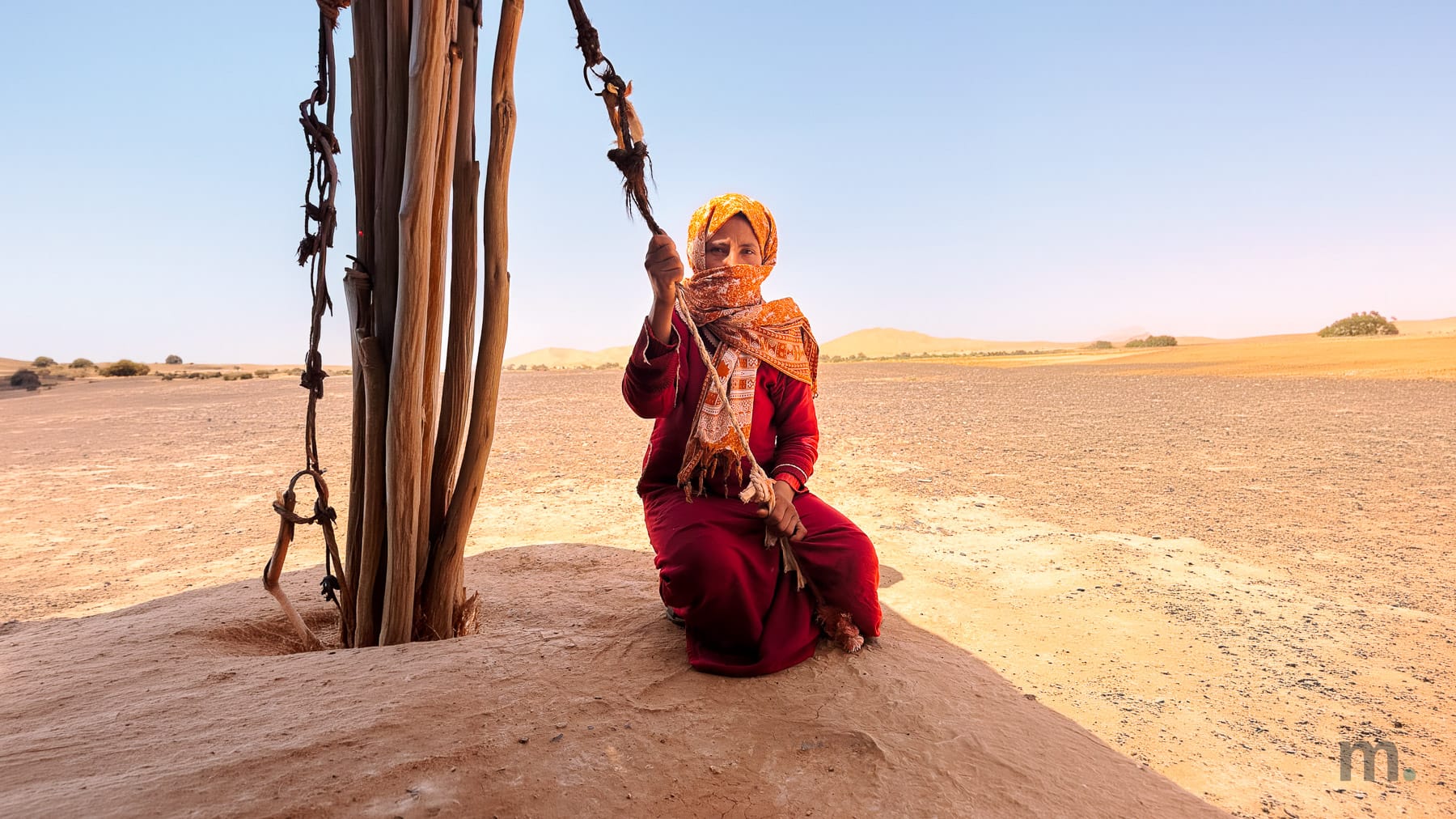 Nomad woman near a tent in the Merzouga desert in the middle of the day