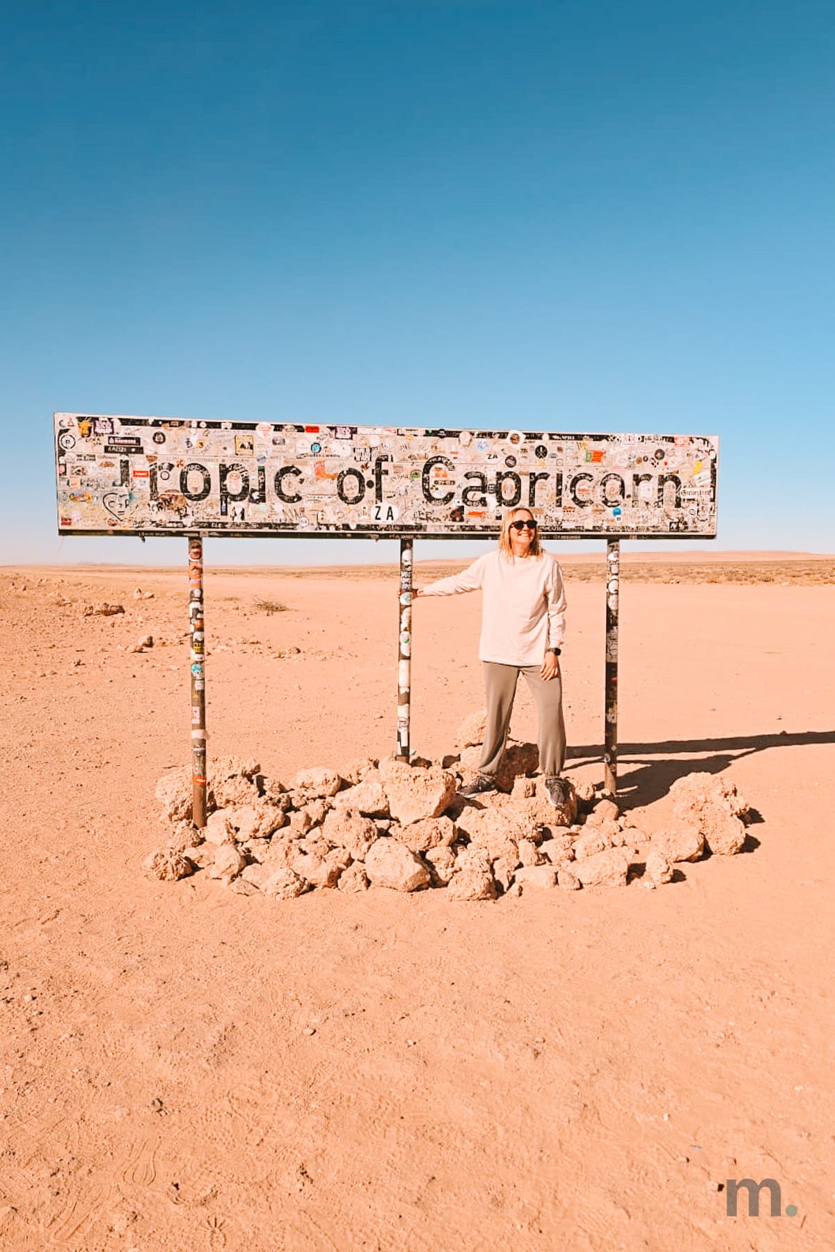 Marlene beside the Tropic of Capricorn sign in the Namib desert