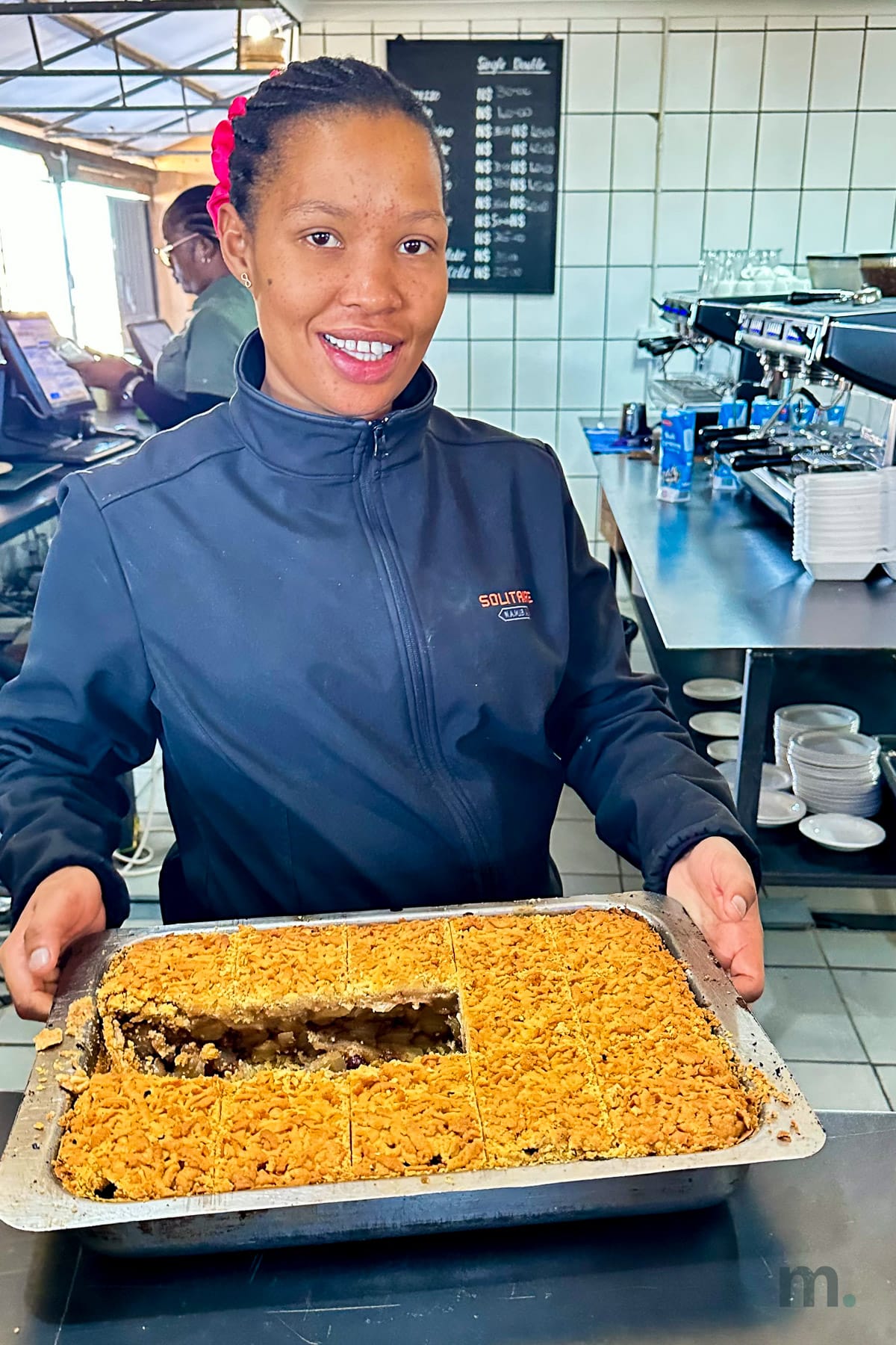 Solitaire bakery worker holding the tray of freshly baked apple pie