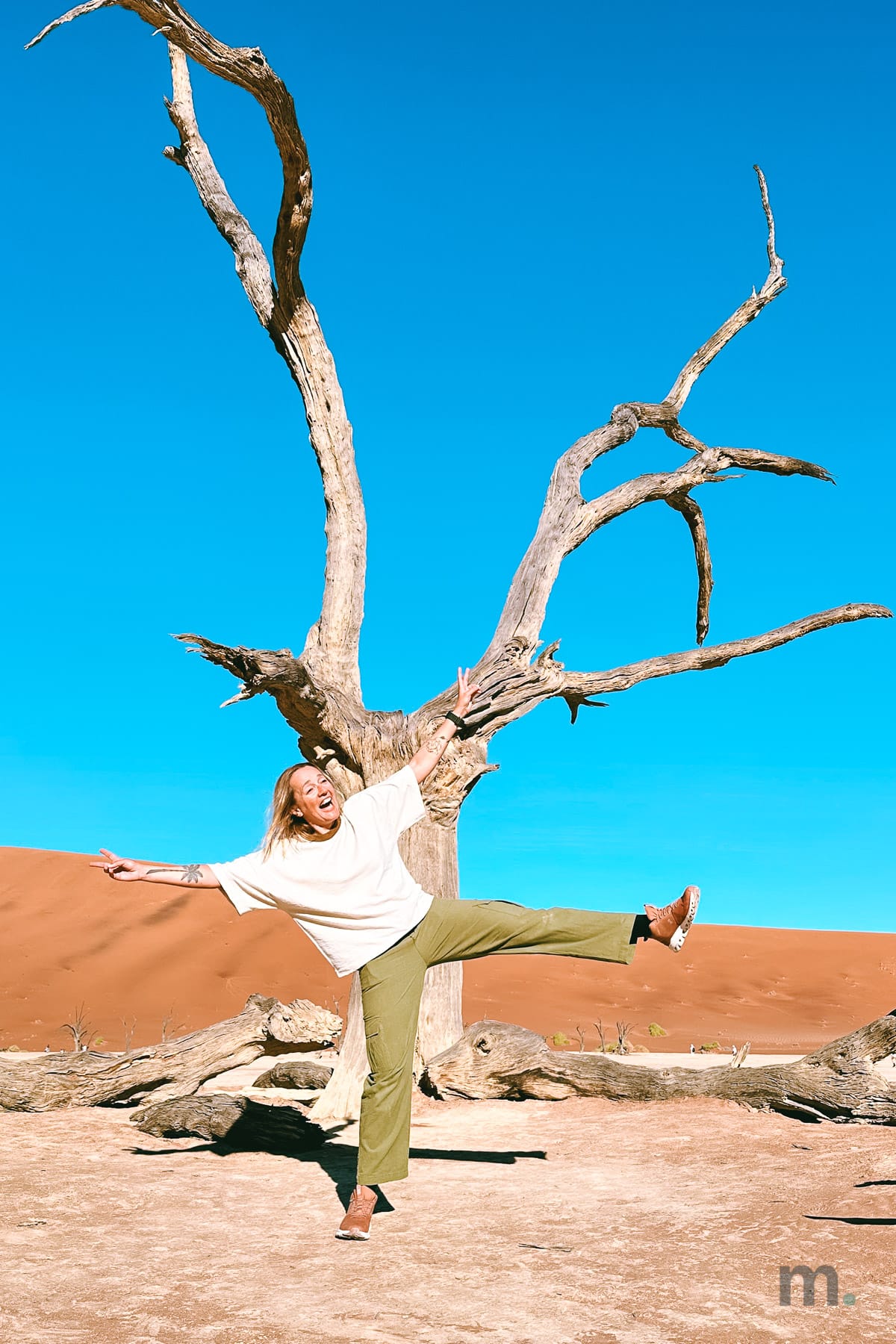 Marlene with arms out in front of a dead tree at Deadvlei, Namibia