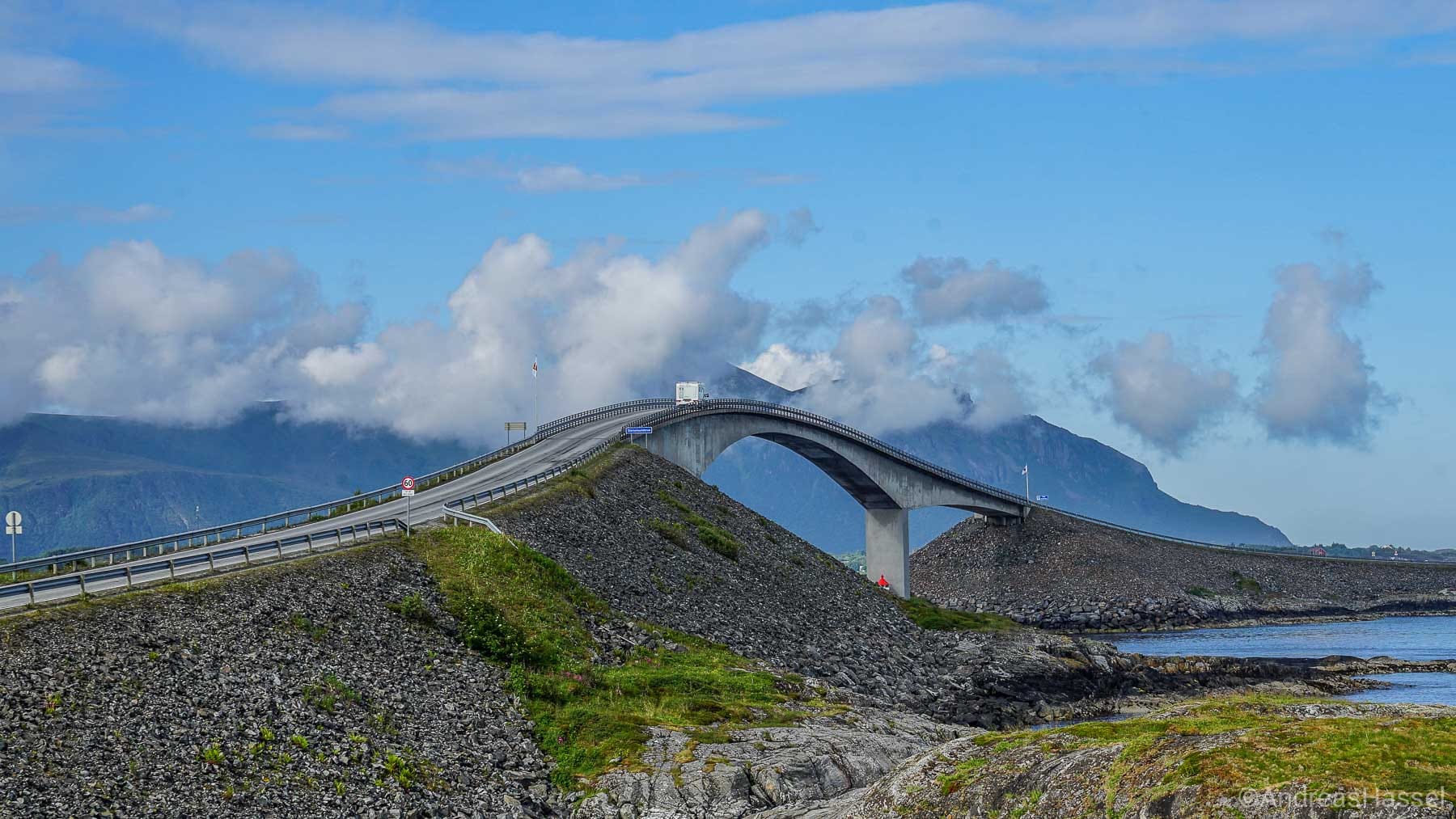 Bridge in Norway that goes over a river with mountains in the background